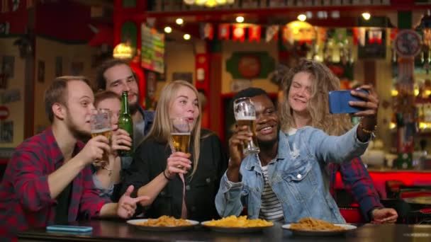 Group of diverse friends taking selfie on mobile phone in bar - Footage, Video