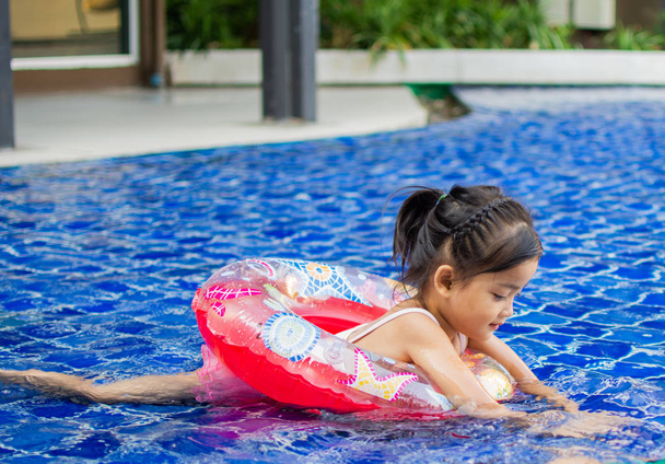 aranyos kislány úgy érzi, boldog játék és úszás uszoda, napsütéses nap és puha fókusz. - Fotó, kép