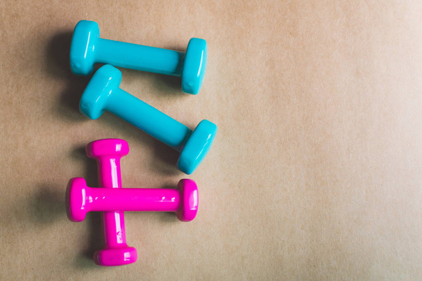 Fitness equipment dumbbells on color background. Flat lay. - Фото, изображение