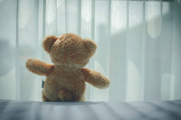 ベッドルームに孤独なクマ人形の後部は、悲しいと低いキーのように感じる. - 写真・画像