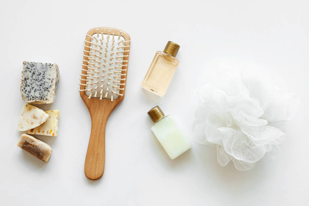 Ploché lázně, kosmetické prostředky pro sprchu. Šampon nebo sprchové gel, mýdlový bar, bavlněný ručník, dřevěný hřeben a mušle. Pohled shora fotografie přírodní kosmetika - Fotografie, Obrázek