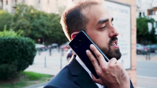 Caucasian man in business suit on the phone outdoor in the city - Кадры, видео