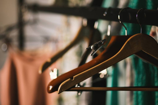 Gros plan sélectif de cintres bruns suspendus sur un étagère
 - Photo, image