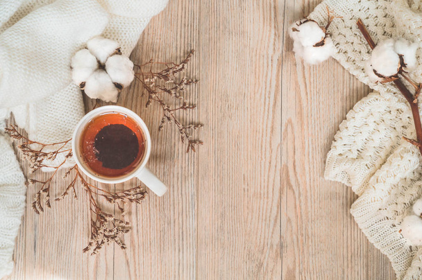 Фон с теплыми свитерами и чашечкой чая. Уютный натюрморт в теплых тонах, пространство для текста
 - Фото, изображение