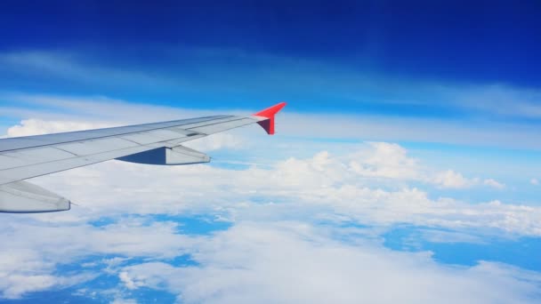 Vliegtuigvleugel en luchtzicht vanuit raam op wolk - Video
