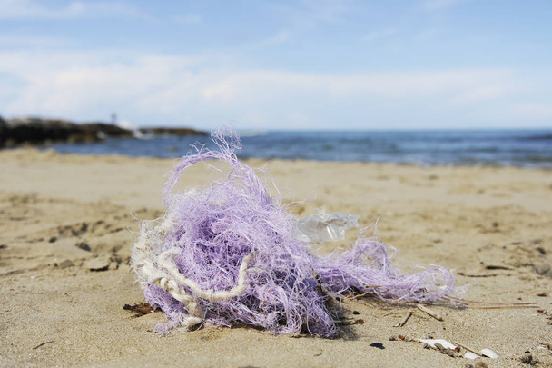 Fishing nylon net on the sand. Garbage on the beach. Dirty sea shore. Environmental pollution. Save the Planet. Ecological problem. Nature theme. - Photo, Image