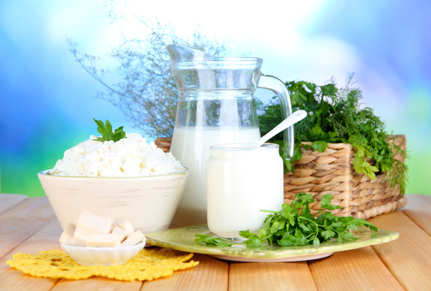 Fresh dairy products with greens on wooden table on natural background - Φωτογραφία, εικόνα