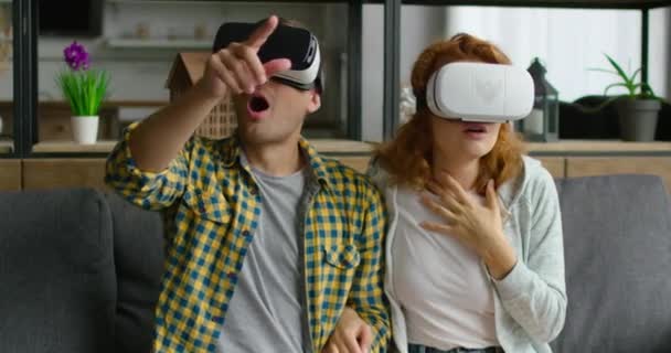 Young couple wears vr headset, react emotionally on virtual reality images - Кадри, відео