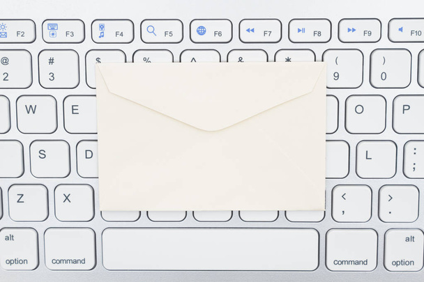 Close-up de um teclado de computador cinza claro com envelope
 - Foto, Imagem
