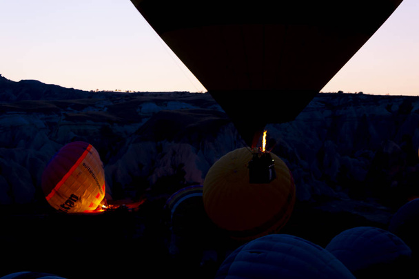 壮大なカッパドキアの上を飛ぶ熱気球 - カッパドキアの丘で熱気球を見ている女の子 - 写真・画像