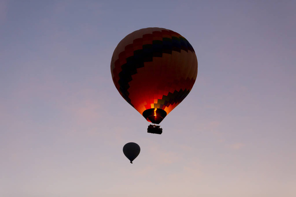 Hot air balloon flying over spectacular Cappadocia - Girls watching hot air balloon at the hill of Cappadocia - 写真・画像