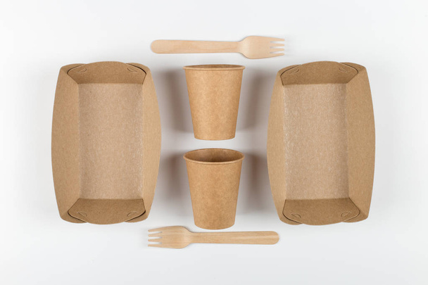Ecological paper utensils, naturally decomposed materials. Plates, cups and wooden forks, a natural set for a picnic. - Photo, Image
