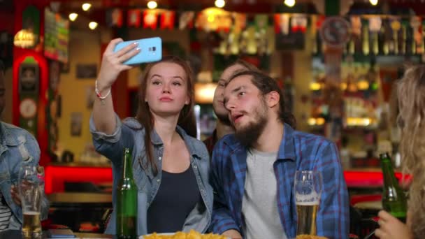 Friends take pictures on the phone at the bar, make a shared photo on the phone. Party with friends at the bar with beer - Footage, Video