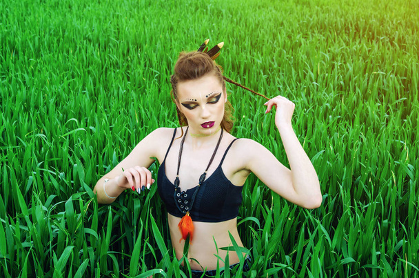 Agressieve make-up meisje, Amazon karakter in een groene tarwe veld. - Foto, afbeelding