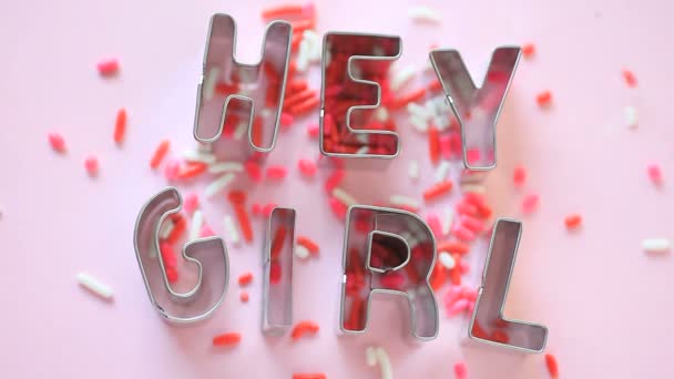 Värilliset strösselit putoavat sanoille Hei tyttö
 - Materiaali, video