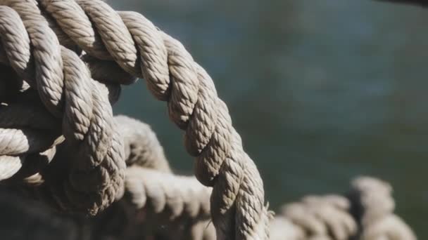 Close-up nautical knot rope tied around stake on boat or ship, boat mooring rope. Marine rope on the ship. The ship leaves the port.  Lighthouse. Mooring rope. Ship in the harbor.  - Footage, Video