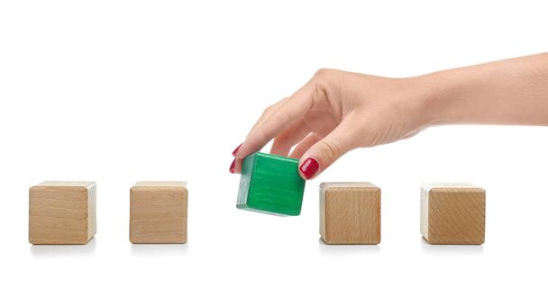 Жіноча рука і дерев'яні кубики на білому тлі. Поняття унікальності або вибору
 - Фото, зображення