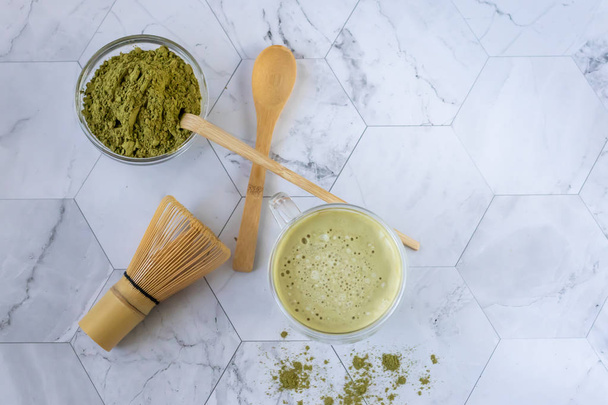 Matcha green latte tea with coconut milk. This latte is a tasty way to enjoy the energy and health benefits of a match. Matcha is a green tea leaf powder filled with antioxidants. - Zdjęcie, obraz