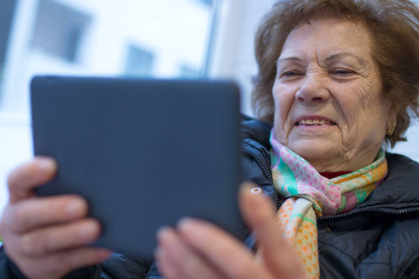 デジタルまたはポータブルタブレットを持つ高齢の女性や祖母 - 写真・画像