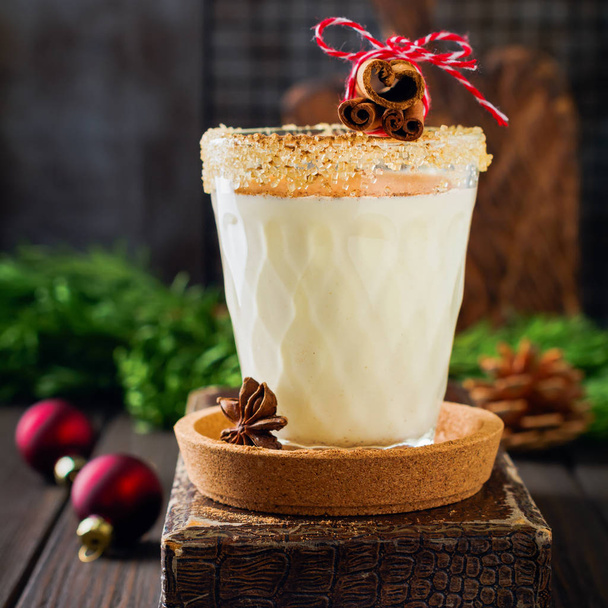 Eggnog Traditional Christmas drink milkshake with cinnamon on dark old background. Square image. Selective focus. - Valokuva, kuva