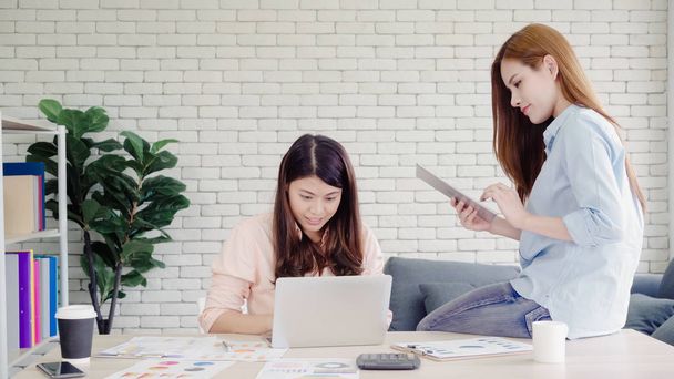 Attrayant intelligent créatif asiatique femmes d'affaires en vêtements décontractés intelligents de travail sur ordinateur portable tout en étant assis sur le bureau sur le bureau. Les femmes travaillent au bureau concept
. - Photo, image