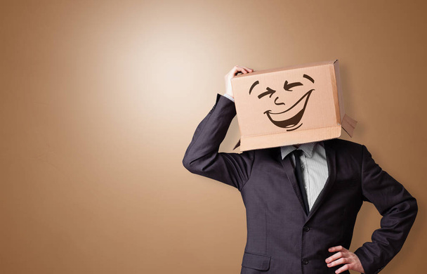 Young boy with happy cardboard box face - Fotó, kép