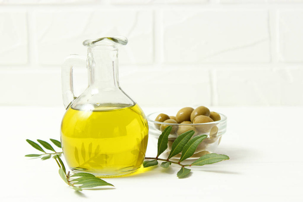 olivový olej, zelené listy a olivy na stole. - Fotografie, Obrázek