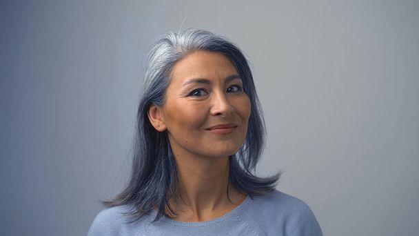 Smiling Asian Woman On The Grey Background - Foto, afbeelding