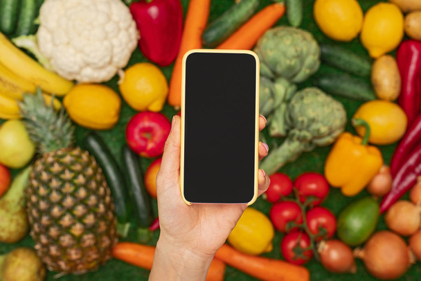 Crop hand with smartphone over healthy food - Фото, изображение