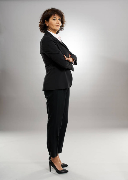 Full length profile of a businesswoman with arms folded - 写真・画像