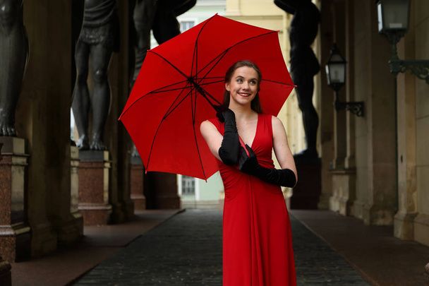Beautiful girl with a red umbrella on a walk in St. Petersburg - Fotó, kép