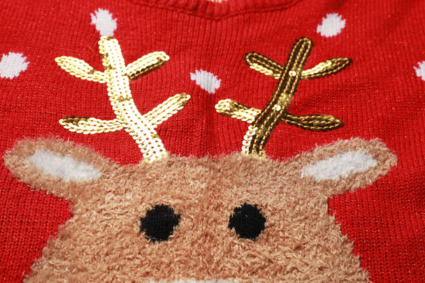 Warm red Christmas sweater with deer as background, closeup view - Fotoğraf, Görsel