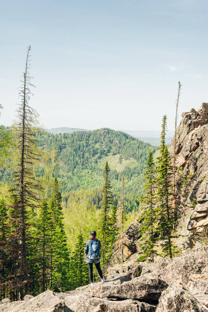 A girl looking straight ahead at the dense coniferous forests. - Photo, Image