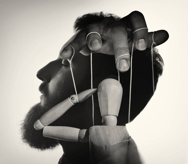 Marionette v mužské hlavě, černá a bílá. Koncept kontroly myšlenek. Obrázek - Fotografie, Obrázek