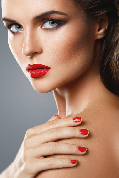 Portrait of beautiful young woman with a red lipstick and nail p - Fotó, kép