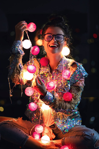 Happy woman wearing glowing jacket with sequins is holding light - Foto, Imagem