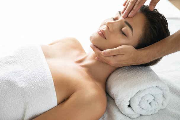 Young and beautiful woman during facial massage session - Photo, image