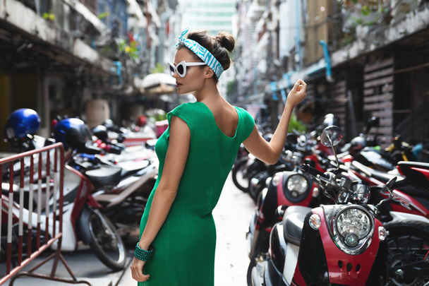 Stylish model wearing green shirt and bandana is posing on the p - Φωτογραφία, εικόνα