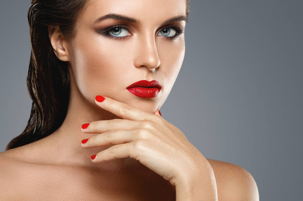 Portrait of beautiful young woman with a red lipstick and nail p - Foto, imagen