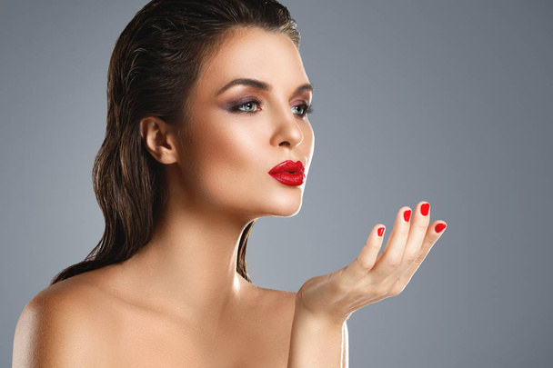 Portrait of beautiful young woman with a red lipstick and nail p - Fotoğraf, Görsel