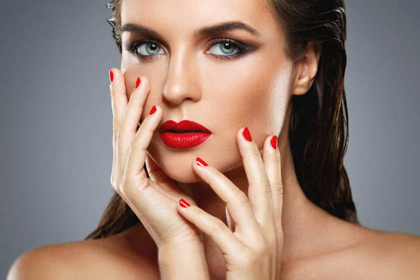 Portrait of beautiful young woman with a red lipstick and nail p - Фото, зображення