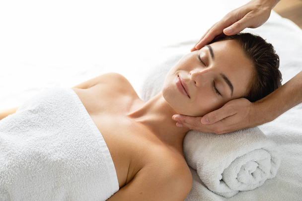 Young and beautiful woman during facial massage session - Photo, Image