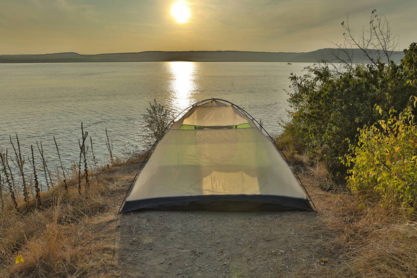 tourism and travel photography of tent stay on edge of cliff in nature reserve scenic environment with  lake water background in sunset time  - Photo, Image