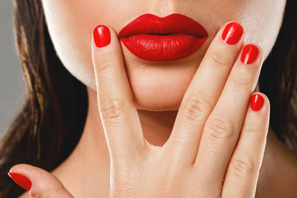 Beauty and cosmetics. Female mouth and nails with red manicure a - Foto, immagini