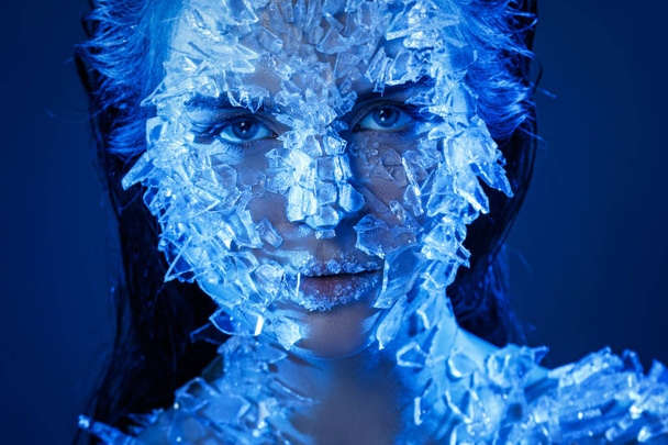 Θηλυκό πρόσωπο καλυμμένο με πολλά μικρά κομμάτια από γυαλί ή πάγο - Φωτογραφία, εικόνα