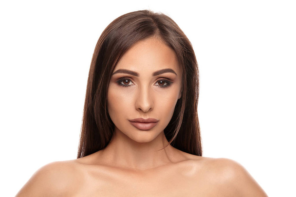 Close up portrait of a brunette nude model girl with professional evening make-up and plump lips, posing isolated on white background. - Φωτογραφία, εικόνα