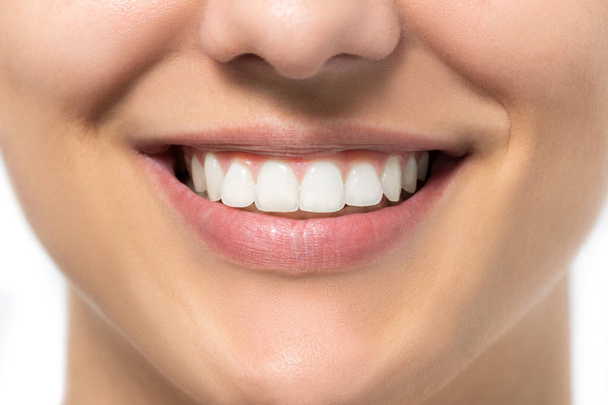 Extrême gros plan de charmant sourire féminin. Jeune femme montrant des dents blanches saines
. - Photo, image