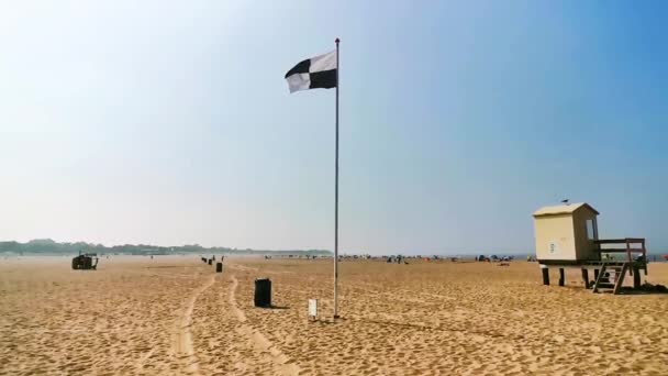 Rüzgarda sallanan siyah ve beyaz damalı bayraklı vrouwenpolder plajı, su sporları izin işareti, Zeeland turistik kıyı köyü, Hollanda - Video, Çekim