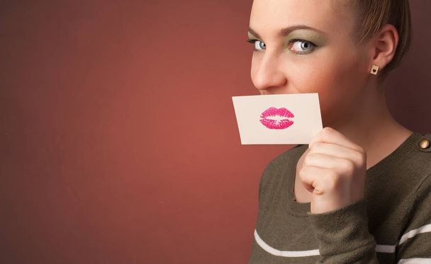 Person smiling with a card in front of his mouth - Foto, imagen