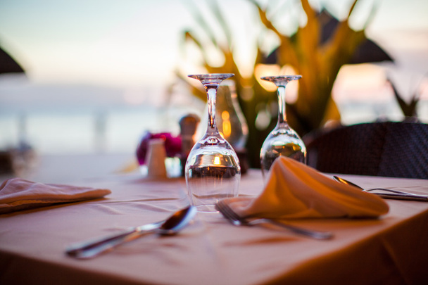Close-up leeg glas wijn op de gedekte tafel bij zonsondergang - Foto, afbeelding